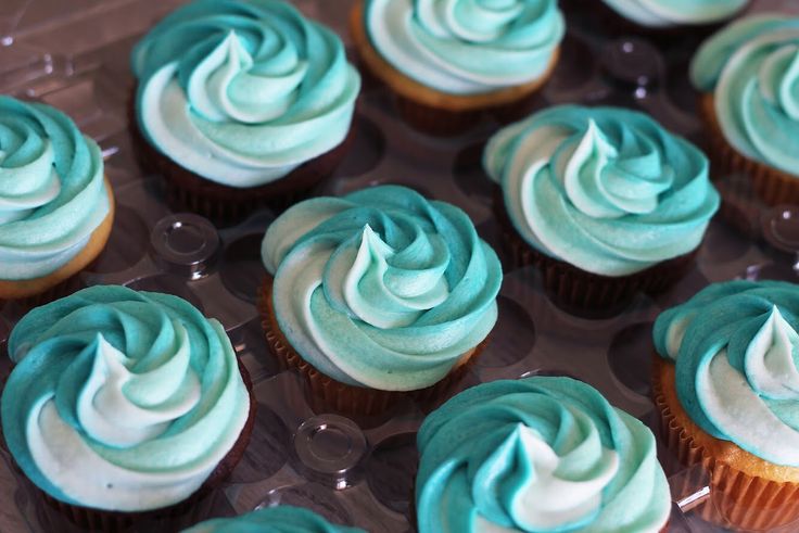 there are many cupcakes with blue frosting on them