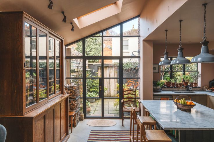 an open kitchen and dining area with lots of light coming in from the windows on the ceiling