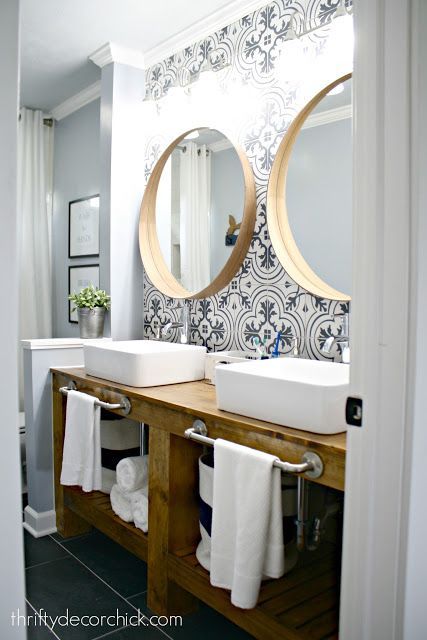 a bathroom with two sinks, mirrors and towels on the rack in front of it