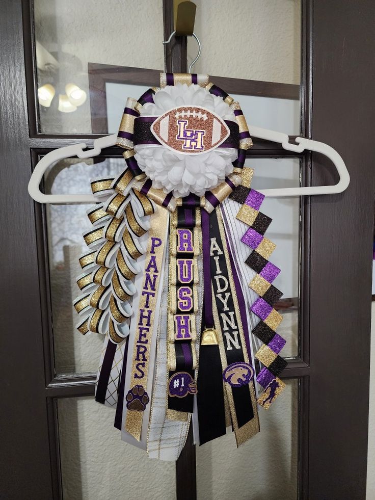 a door hanger decorated with ribbons and footballs on it's front porch