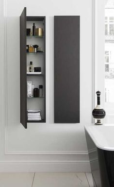 a white bath tub sitting next to a black shelf