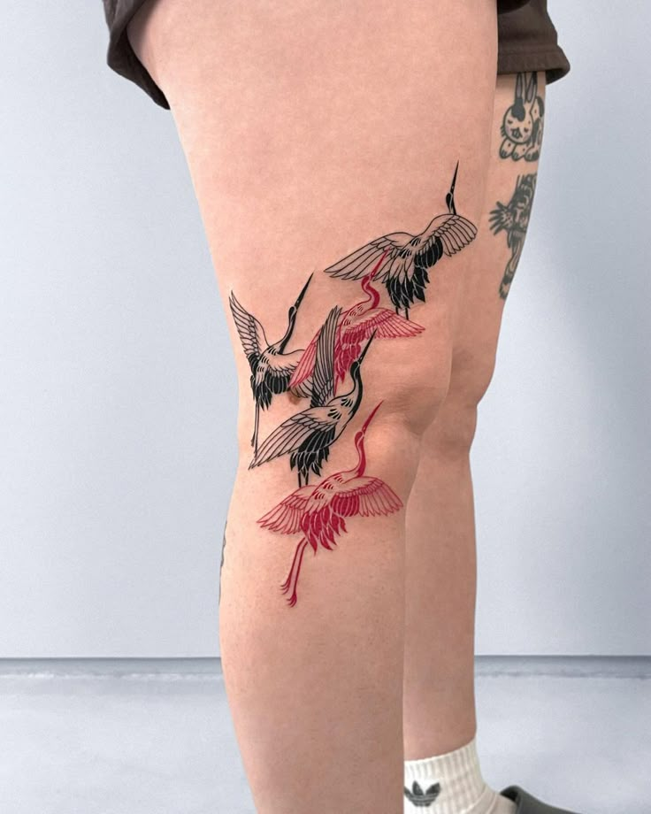 a woman's legs with tattoos on them and one bird flying in the air