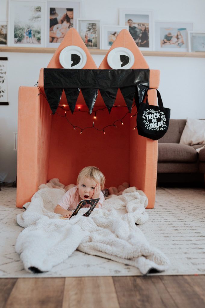 a toddler laying on the floor in front of a fake monster bed with lights