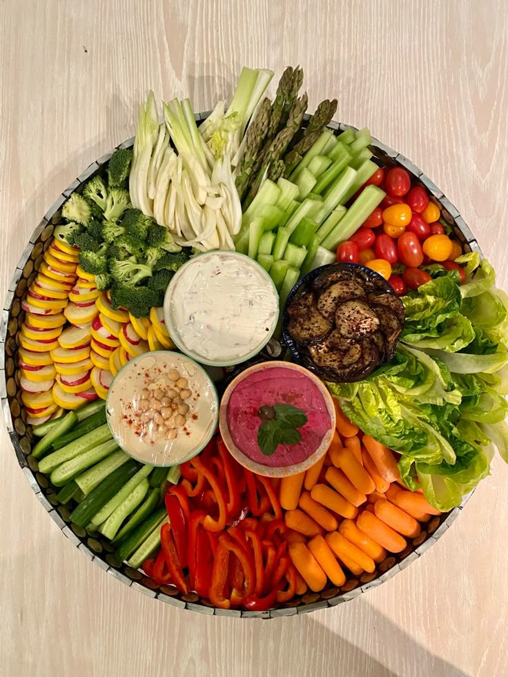 a platter filled with assorted vegetables and dips