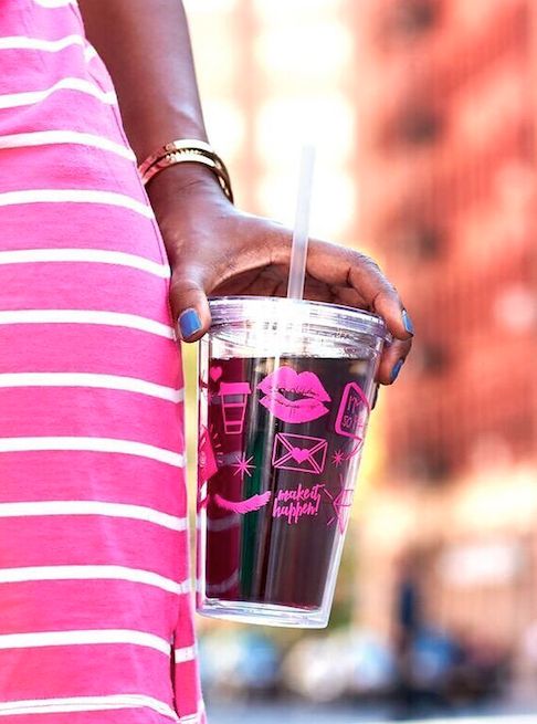 a woman holding a cup with a straw in her hand