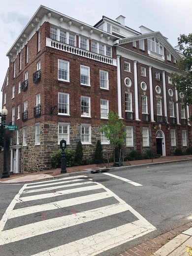 an old brick building on the corner of a crosswalk in front of a traffic light