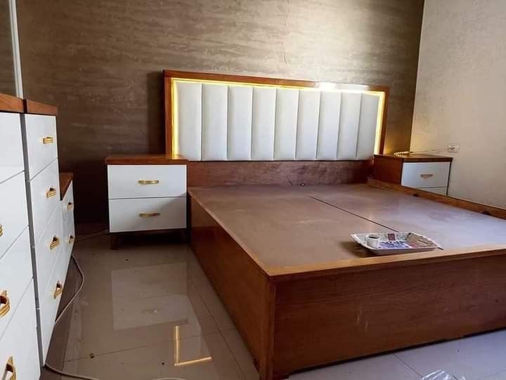 a bedroom with a bed, dressers and drawers on the floor next to each other