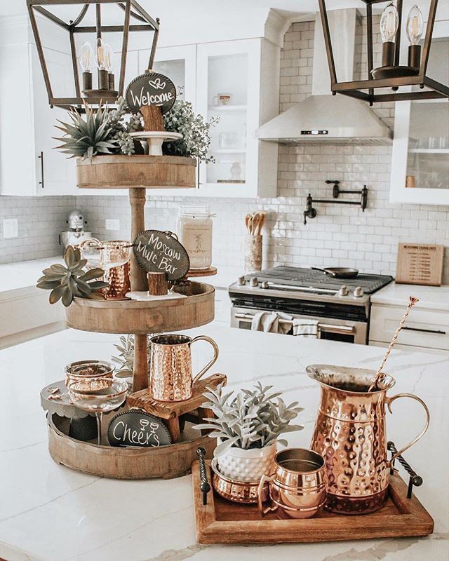 three tiered trays filled with pots and pans on top of a kitchen counter