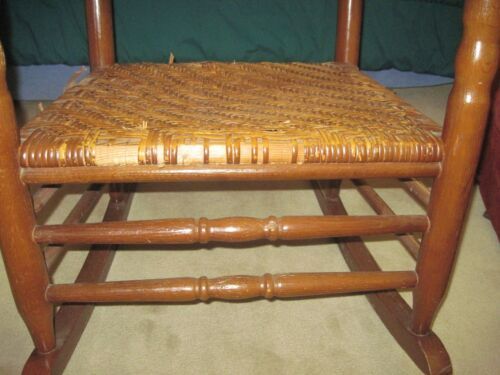 a wooden rocking chair sitting on top of a carpeted floor