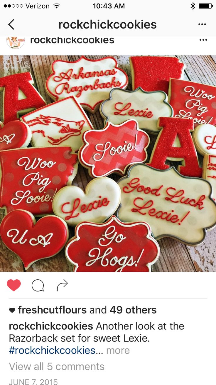 some cookies that are sitting on top of a wooden table with red and white icing