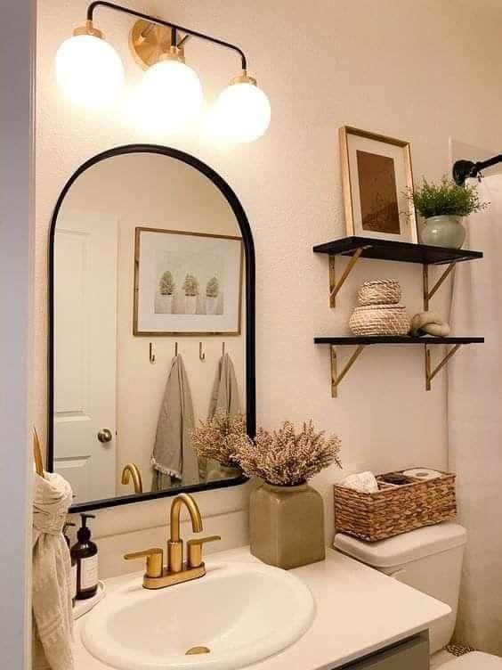 a bathroom with a sink, mirror and shelves on the wall in front of it