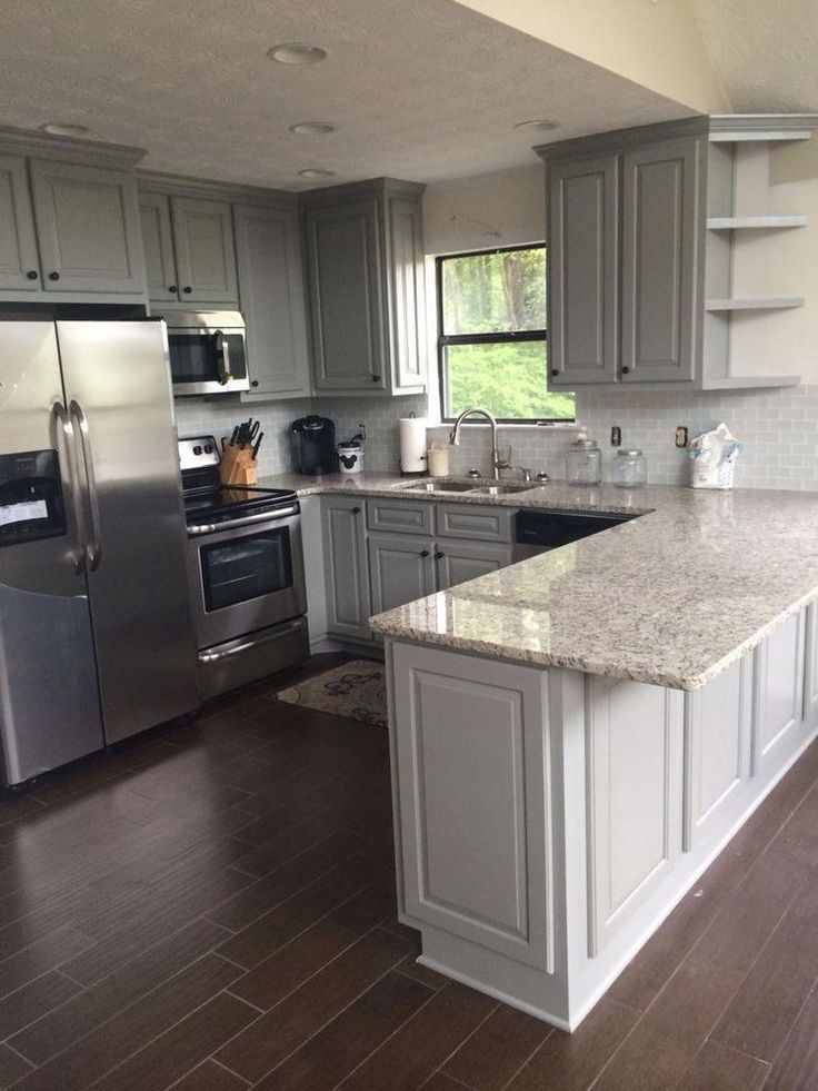 a kitchen with stainless steel appliances and granite counter tops, along with hardwood flooring