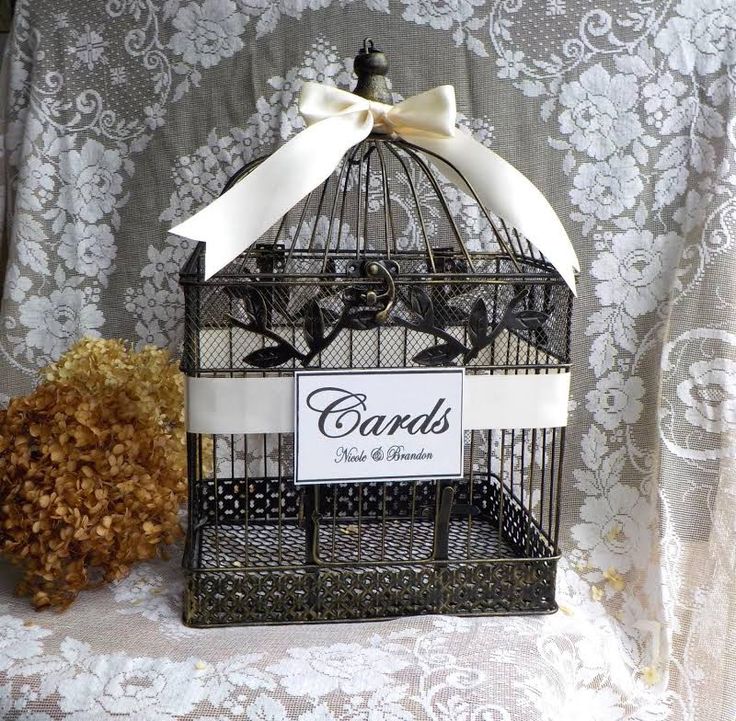 a birdcage with a sign that says cards tied to the front and bottom