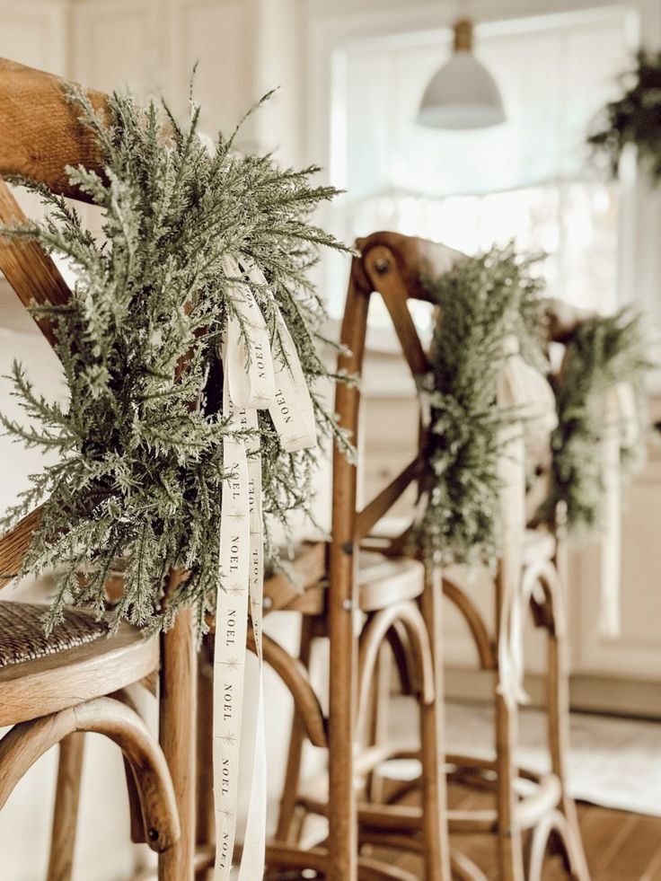 three wooden chairs with wreaths on them in a kitchen area next to a bar stool