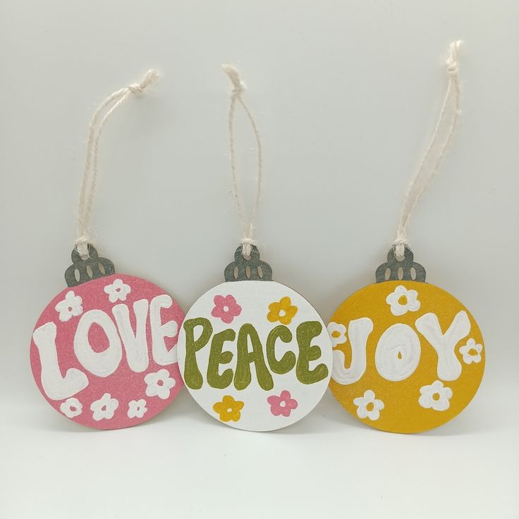 three ornaments that say love, peace and joy