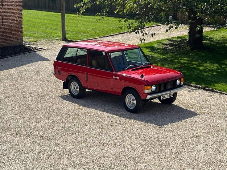 a small red car parked in a driveway