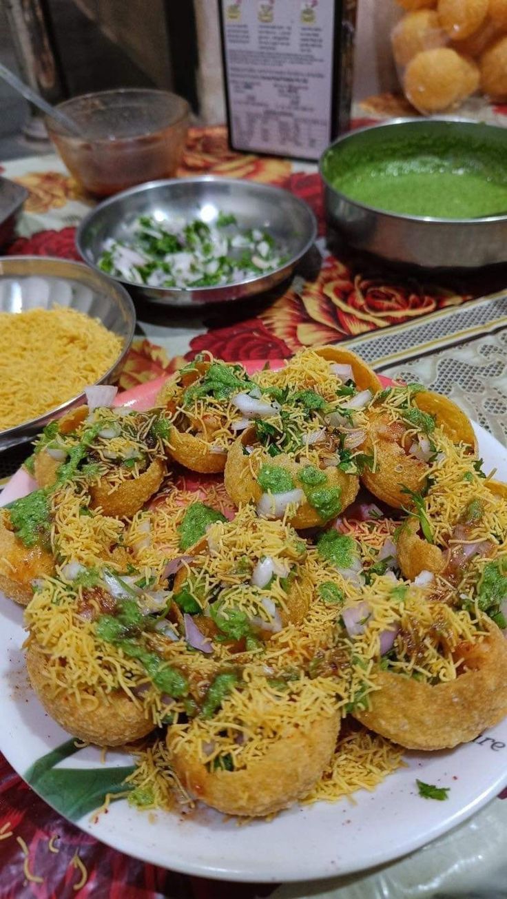 a plate full of food sitting on top of a table next to bowls and spoons