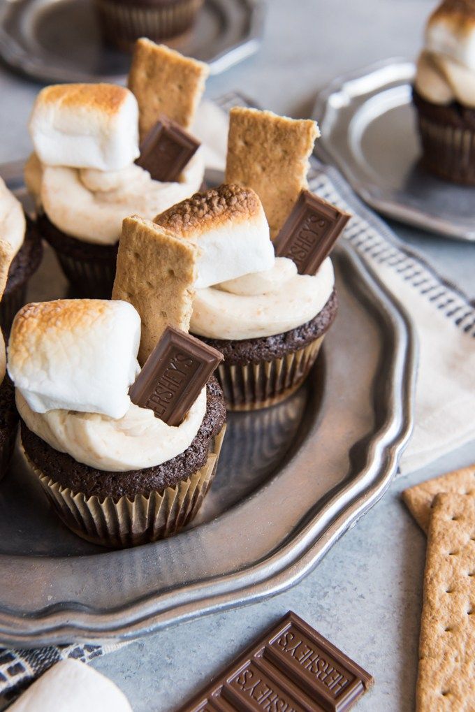 chocolate cupcakes with marshmallows and graham crackers on a plate