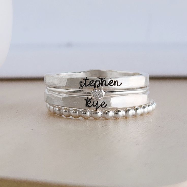 Mother's Day Gift | Personalized stackable ring set, engraved with a name, date, or special word.  Metal: 14k gold filled, 14k rose gold filled, or .999 fine silver Dimensions: name rings are 2mm tall on average, but our rings are handmade so variations will occur. Birthstone is 2mm on a 1mm band and beaded ring is 2mm. Font: lowercase typewriter or lowercase cursive If you leave one name, we will put a heart on the second ring unless you request that it remains blanks. If you have 3 or 4 names, Minimalist Stackable Jewelry For Personalized Gifts, Personalized Silver Engraved Ring For Mother's Day, Personalized Sterling Silver Rings For Mother's Day, Customizable Sterling Silver Engraved Ring For Mother's Day, Customizable Sterling Silver Ring For Mother's Day, Customizable Silver Engraved Ring For Mother's Day, Hand Stamped White Gold Jewelry For Wedding, White Gold Hand Stamped Jewelry For Wedding, Custom Name Engraved Sterling Silver Ring Gift