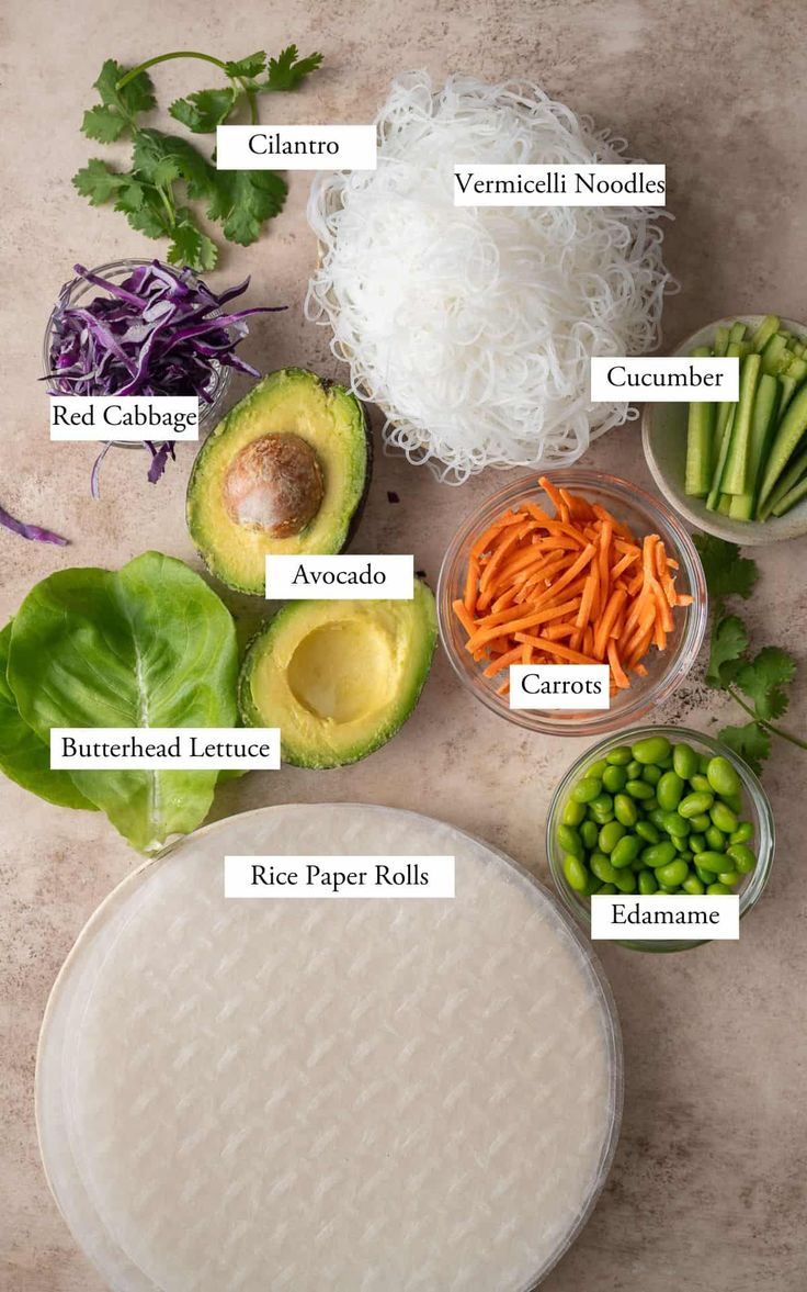 the ingredients for this salad include carrots, avocado, cabbage, red cabbage, cucumber, and rice paper rolls