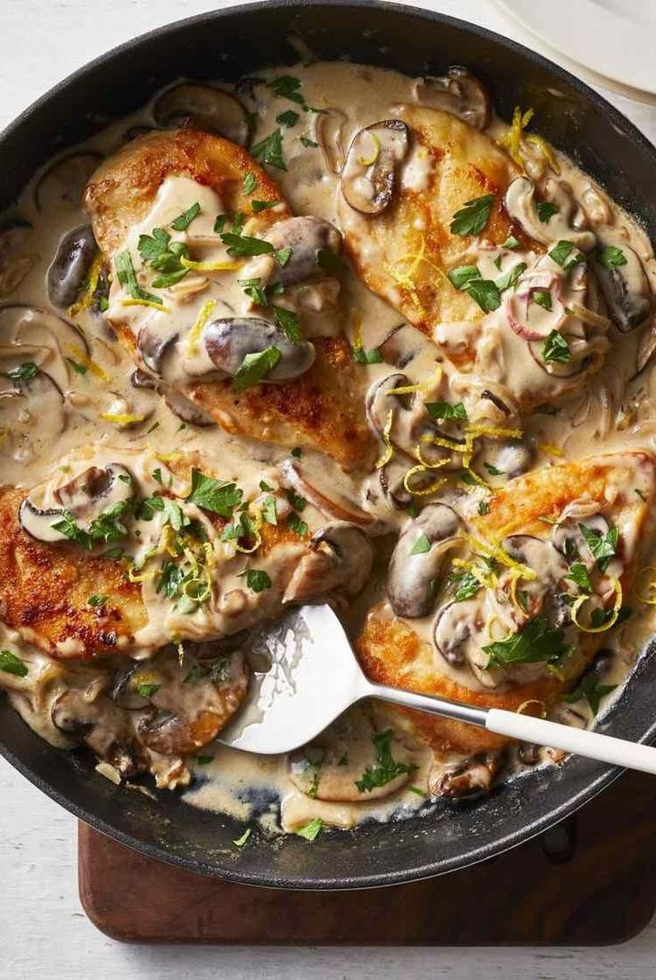 a skillet filled with chicken covered in mushroom gravy