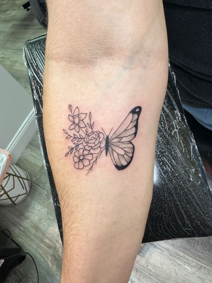 a butterfly and flowers tattoo on the arm