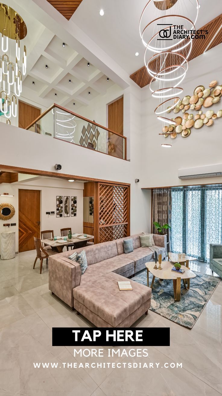 a living room filled with furniture next to a staircase and chandelier hanging from the ceiling