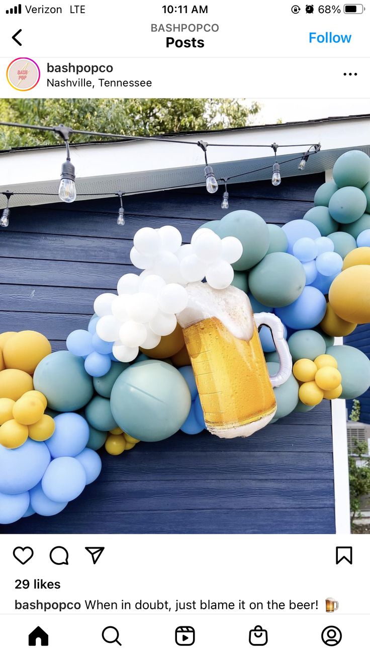 a beer mug sitting on top of a table next to some balloons and streamers