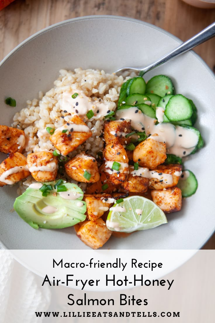 a white bowl filled with rice and shrimp next to cucumber, lime wedges