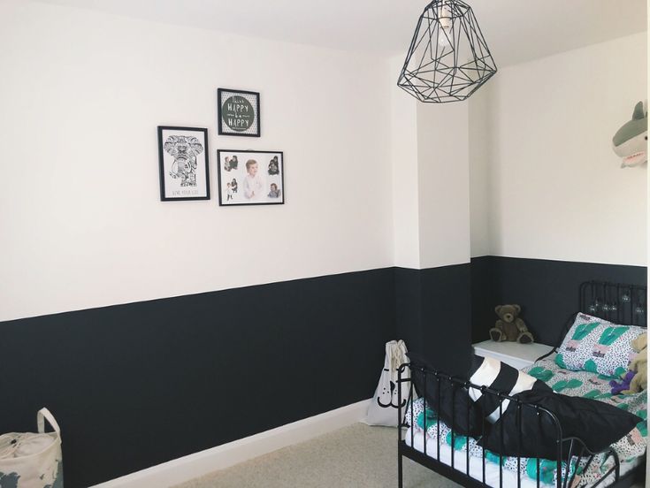 a black and white striped wall in a child's room with a crib