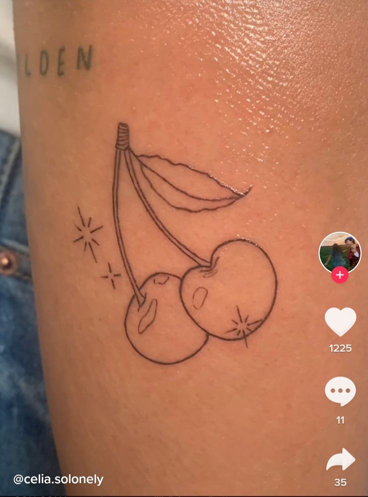 a tattoo on the leg of a woman with a cherries head and leaves attached to it