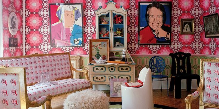 a living room decorated in pink and white with pictures on the wall, chairs and rugs