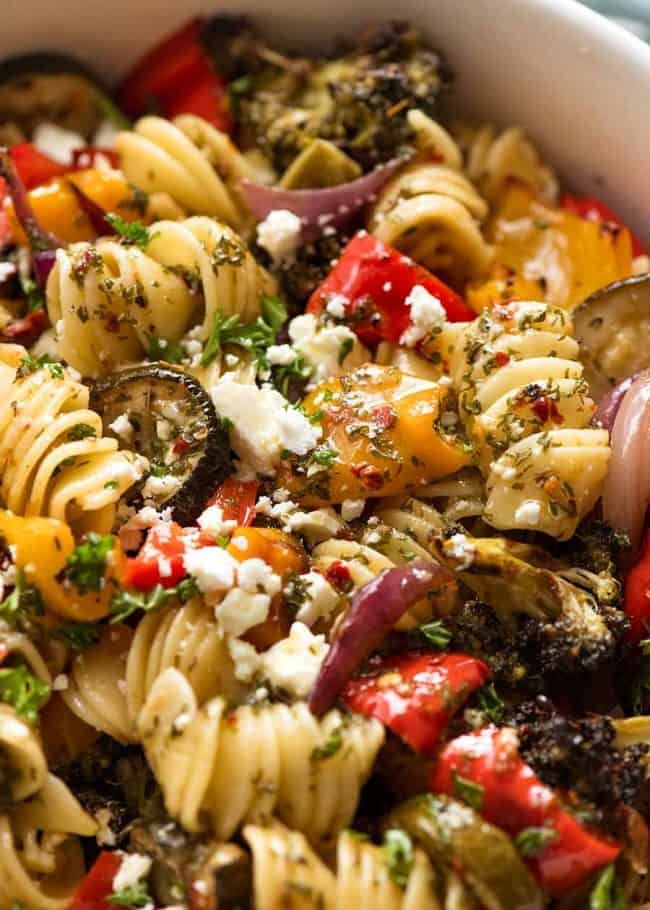 a bowl filled with pasta and vegetables on top of a table