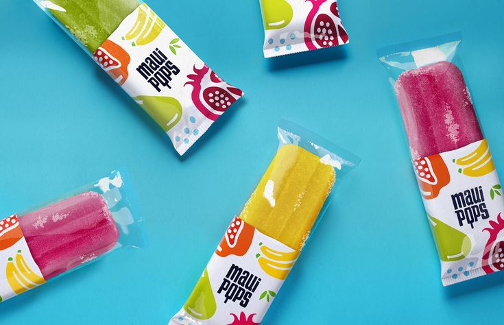 three pops are packaged in plastic bags on a blue surface, with fruit flavored pops sticking out of them