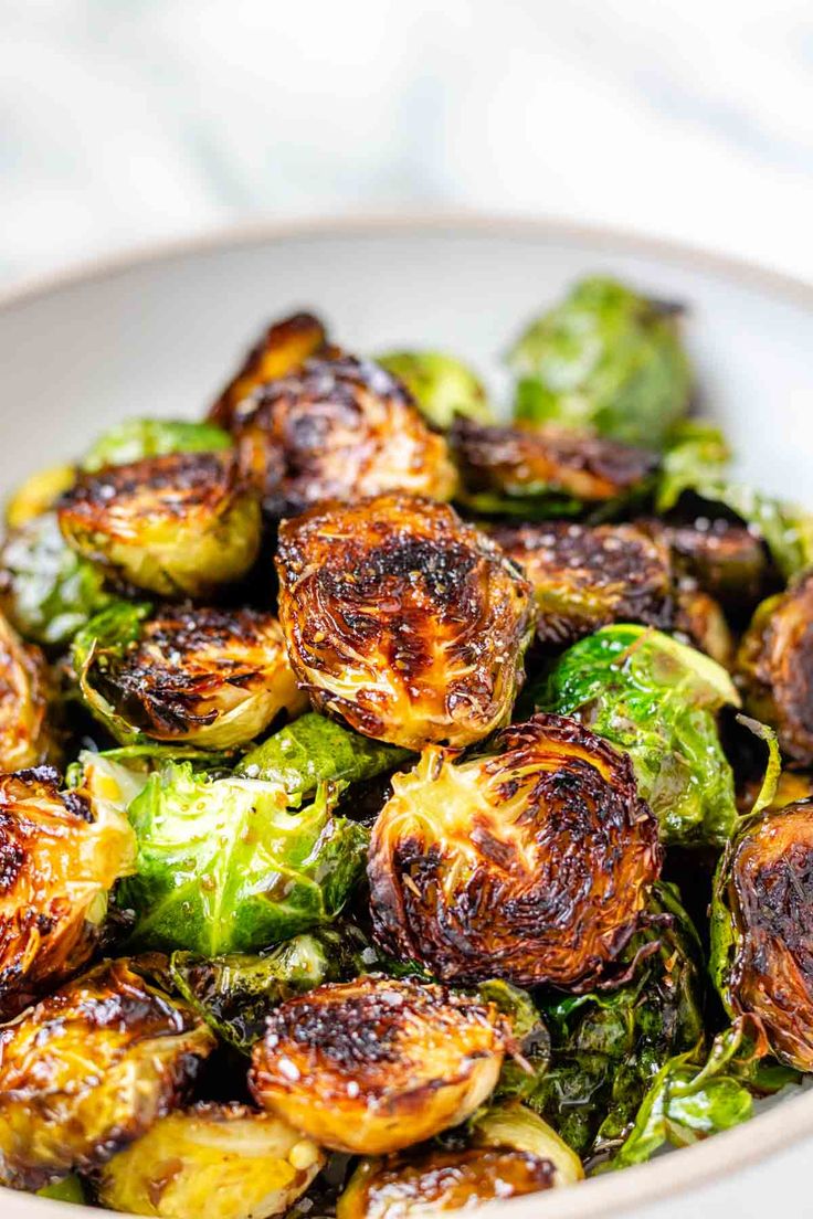 a white bowl filled with brussel sprouts on top of a table