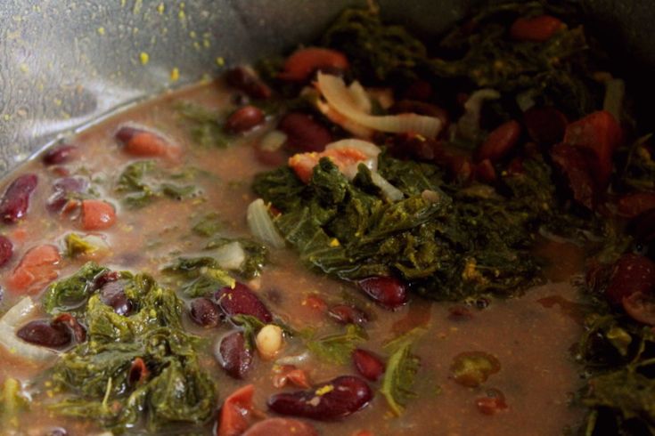 a pot filled with lots of food on top of a stove burner and broccoli