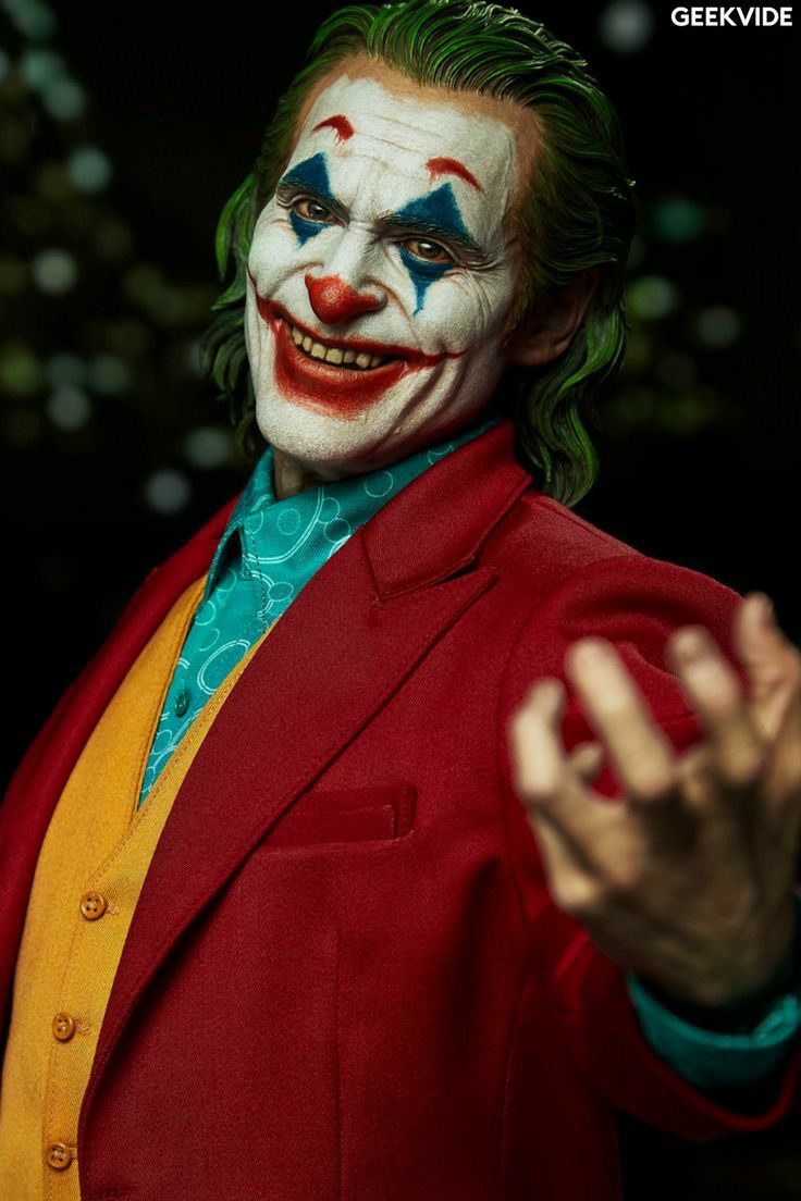 a close up of a person wearing a clown mask and holding his hands out to the side