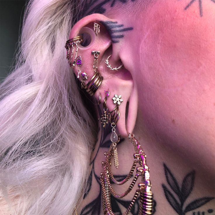 a woman with tattoos and piercings on her ear