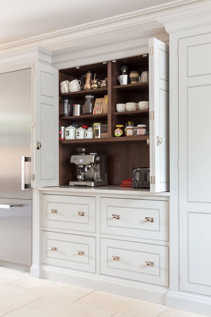 a kitchen with white cabinets and drawers