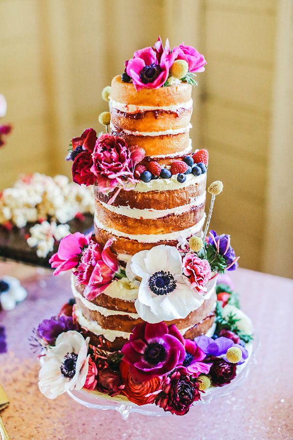 there is a multi layer cake with flowers on the top and bottom, sitting on a table