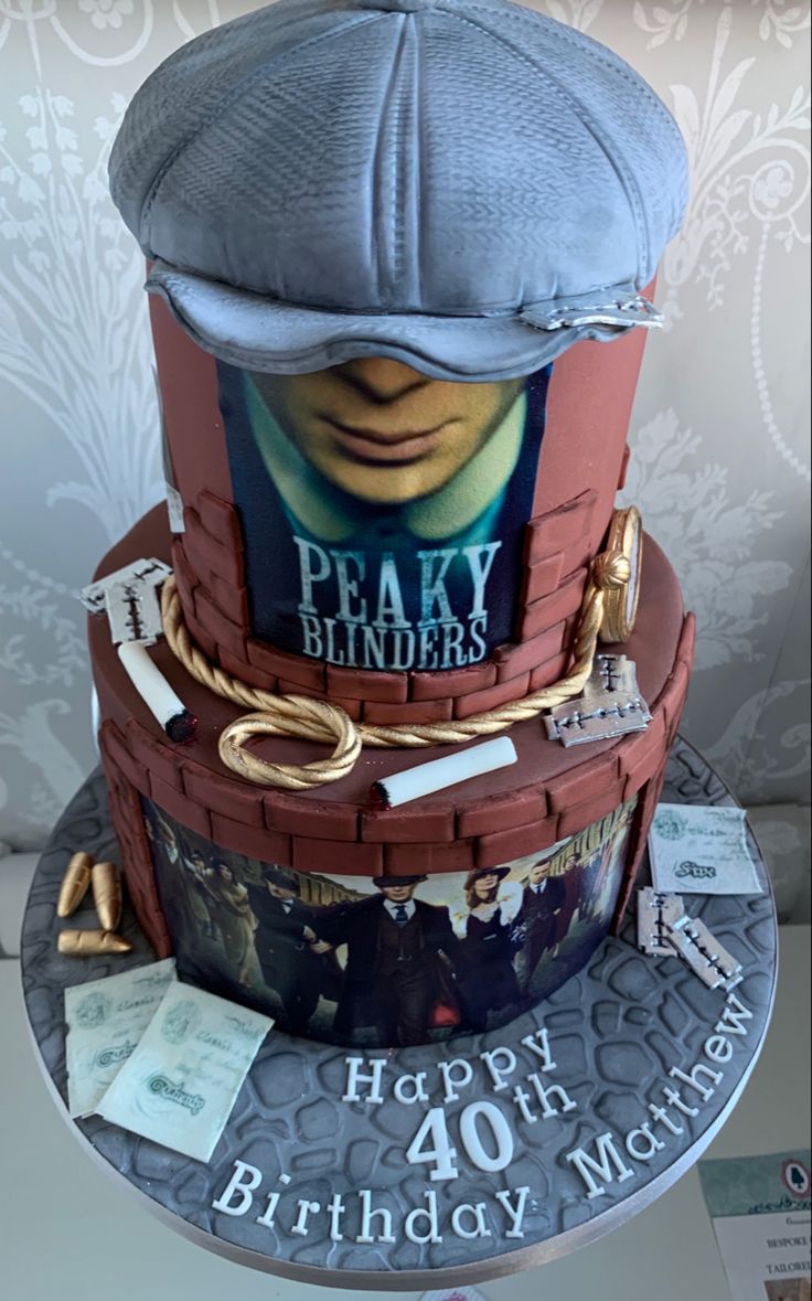 a birthday cake made to look like a stack of books with a hat on top