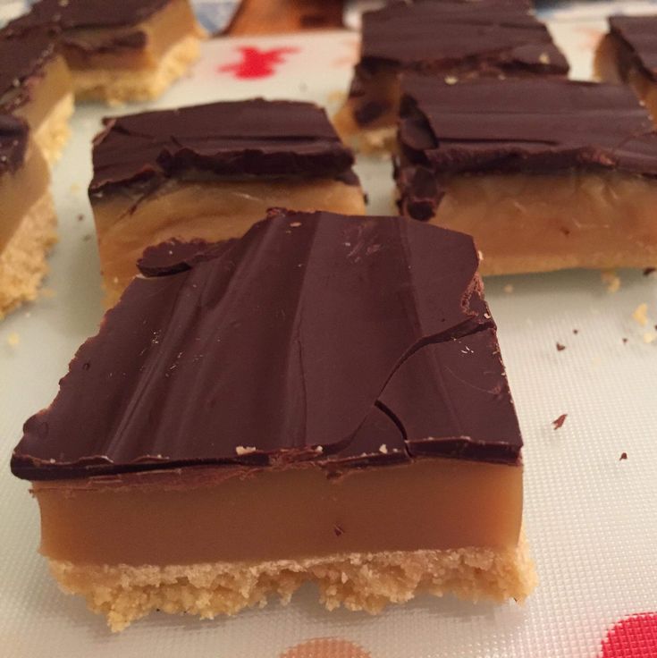 several pieces of chocolate and peanut butter bars on a table