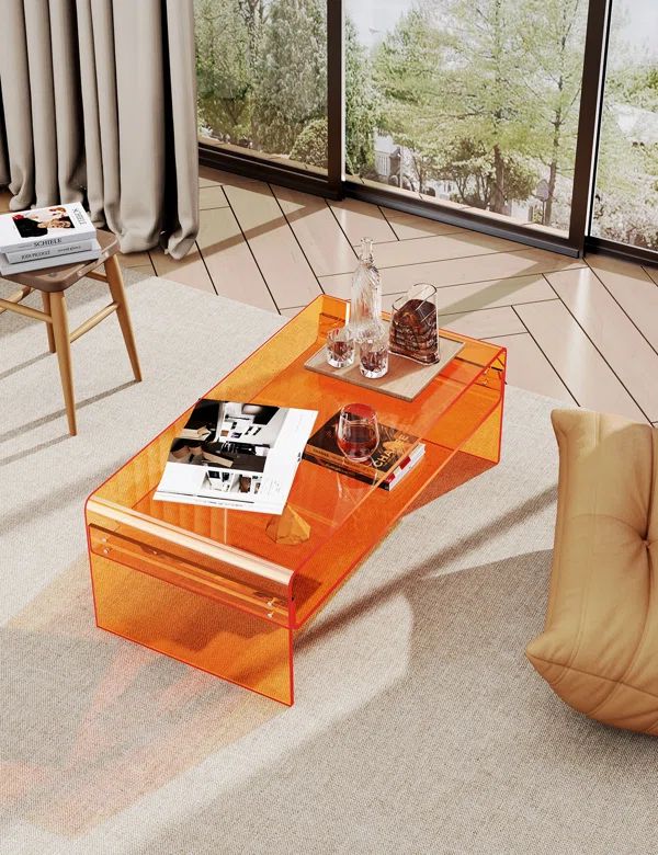 an orange coffee table sitting on top of a carpeted floor next to a window