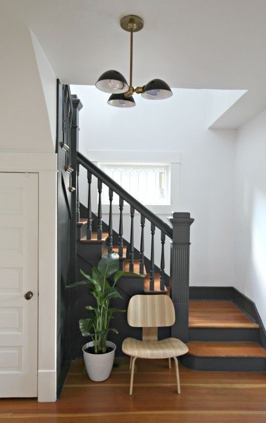 a wooden chair sitting on top of a hard wood floor next to a stair case