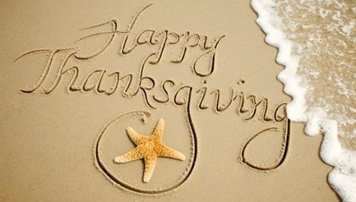 happy thanksgiving written in the sand with a starfish and seashell on it's side