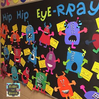 a bulletin board that has been decorated with colorful paper monsters and words on the blackboard