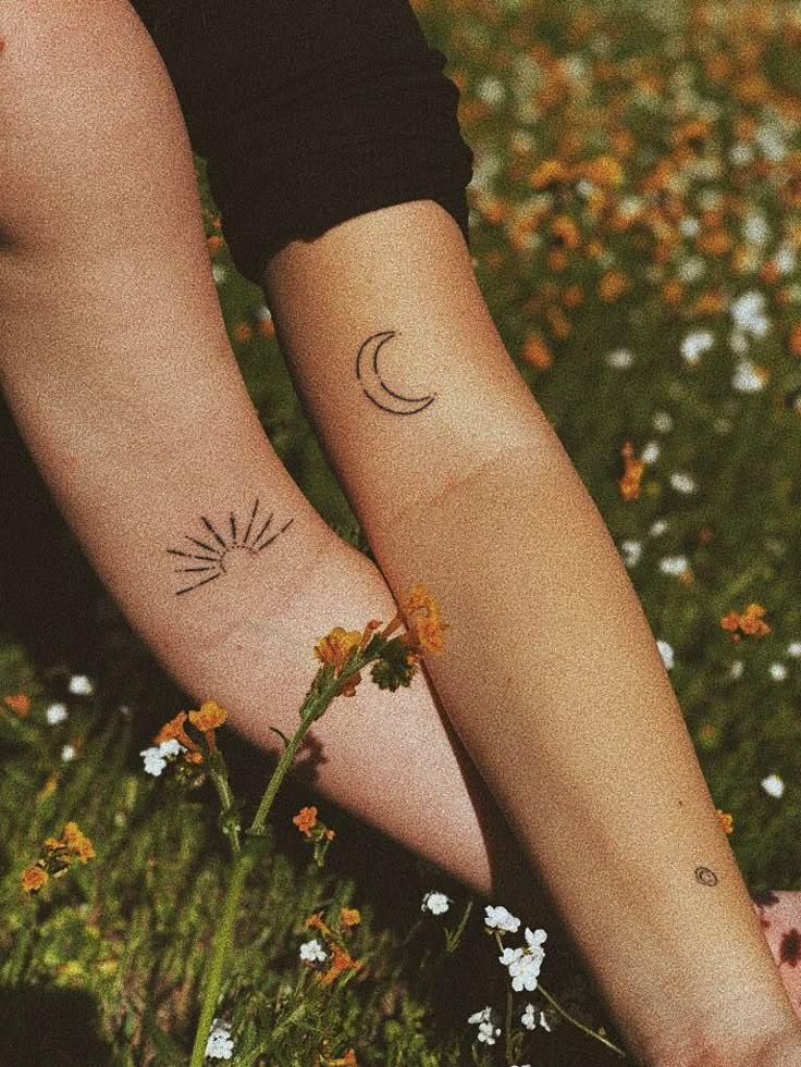 two people with matching tattoos on their arms and legs, both holding each other's hands