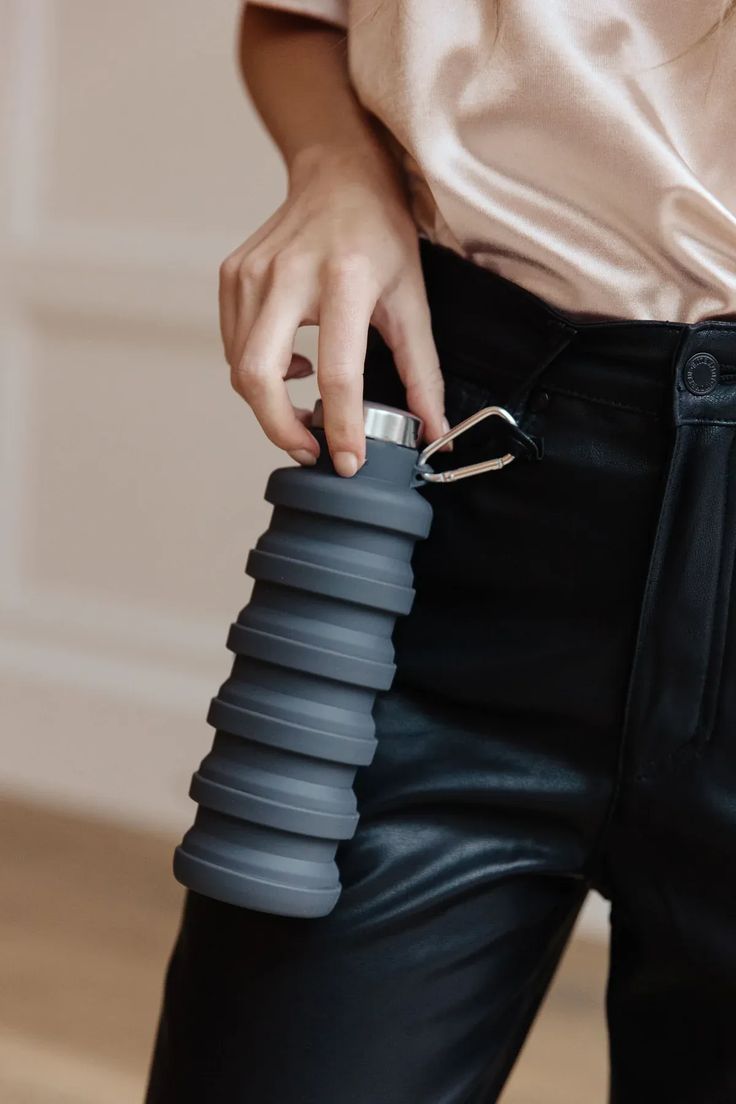 a person holding a water bottle in their pocket