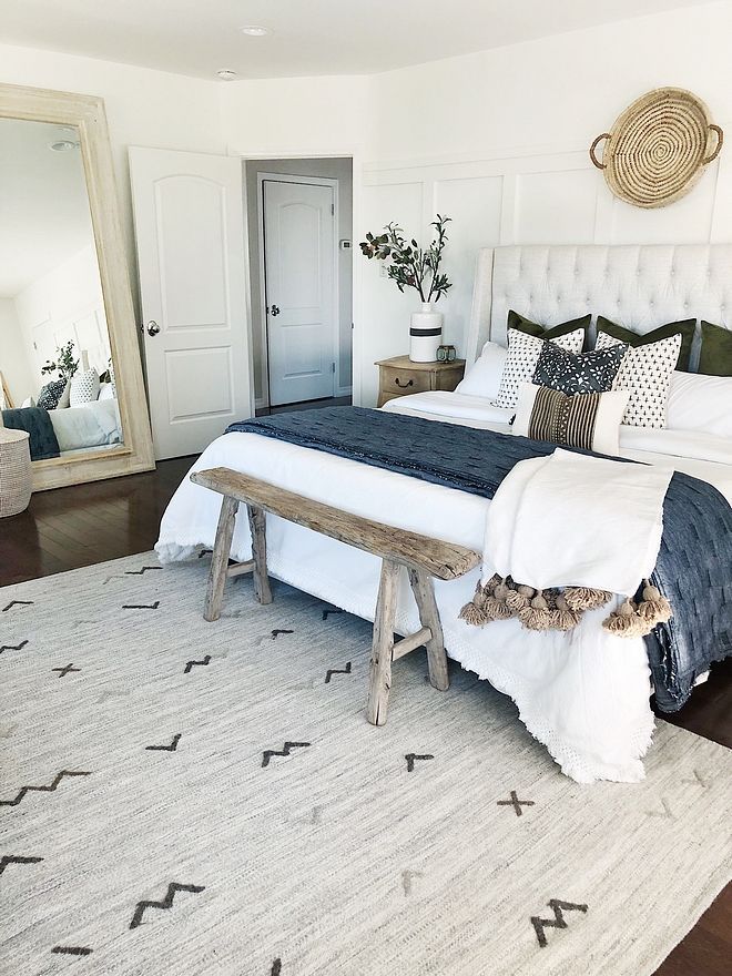 an instagram photo of a bed with pillows and blankets on it, along with a bench in front of the bed