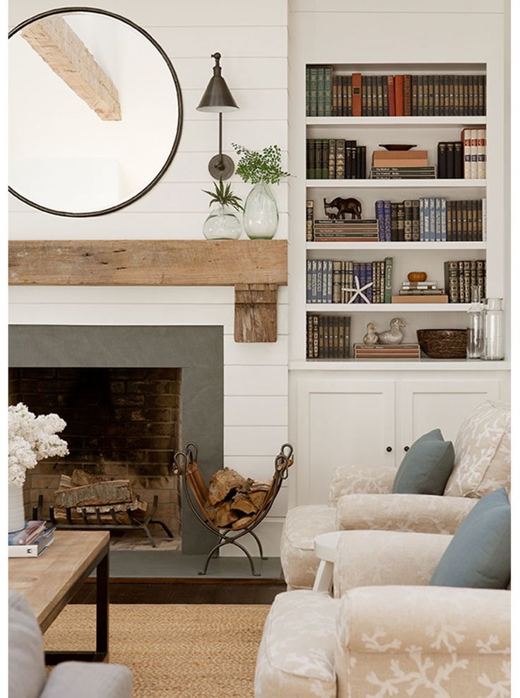 a living room filled with furniture and a fire place in front of a book shelf